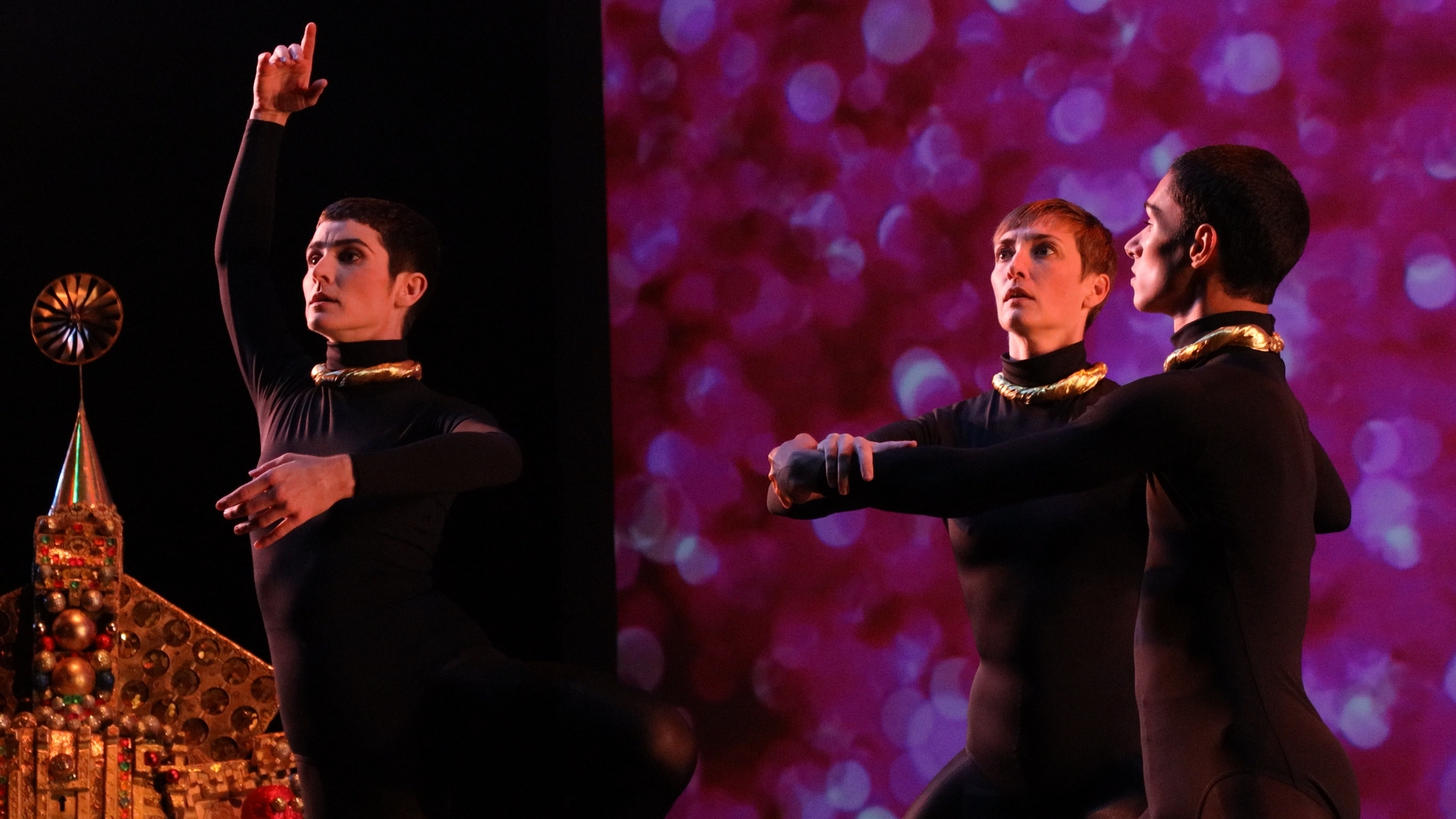 People dressed in black standing together with a dark background