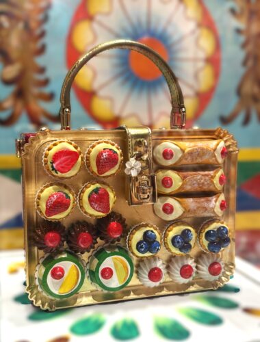 n the display dedicated to Sicily, a whimsical purse is decorated with jeweled cannoli and other regional sweets in "From the Heart to the Hands: Dolce & Gabbana." (Photo by Jane Wooldridge)