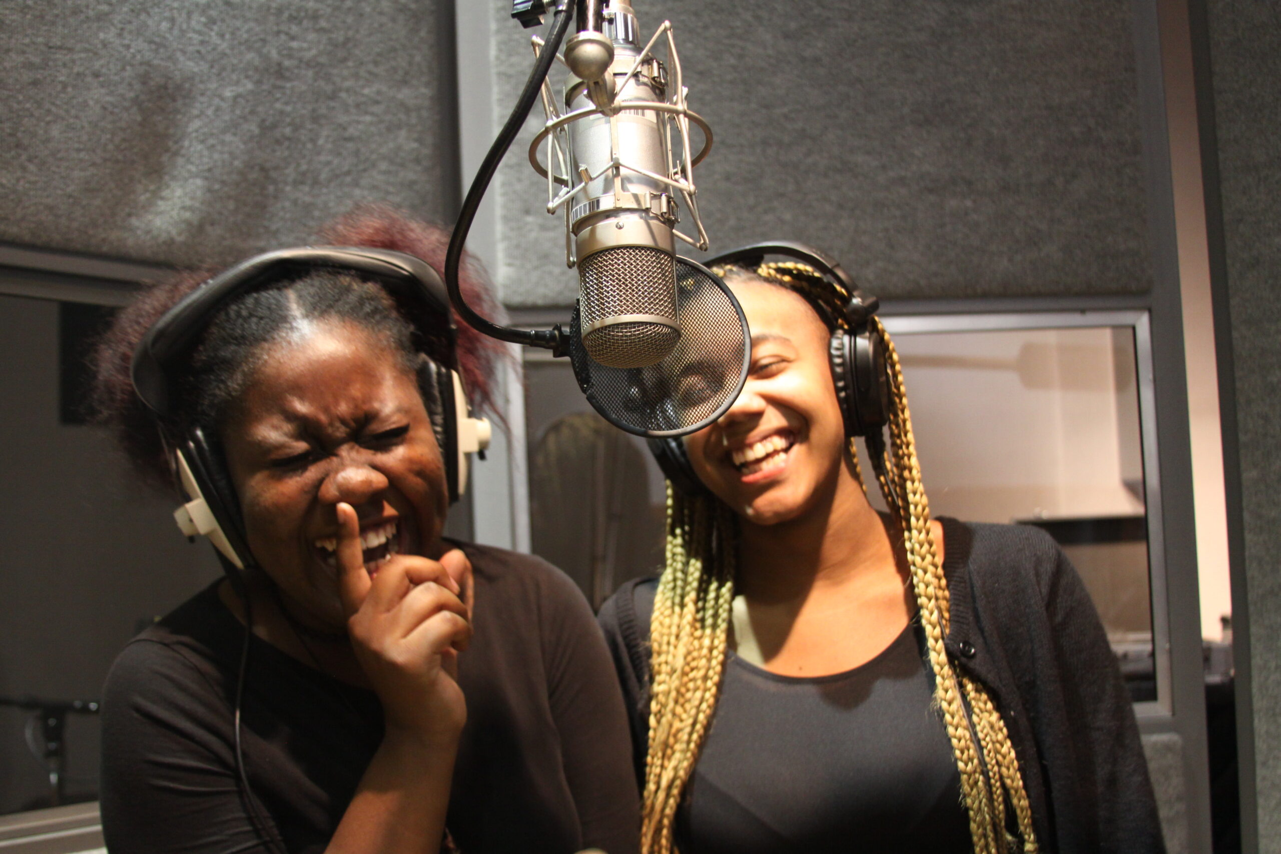 Two girls singing in recording studio