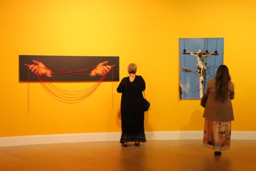 ilvia Dorfsman, local art dealer and appraiser, views Karim Borjas’ “Ecce Homo” (2006), a photographic installation featuring red strings, while Olga Garcia-Mayoral, curator and writer, reflects on Erik Ravelo’s “Señor, Dame Luz” (2009), a C-print. “The Light of the World,” curated by Carol Damian and Adriana Herrera, is on view through Wednesday, May 6, at the Olga M. and Carlos A. Saladrigas Gallery at Belen Jesuit Preparatory School. (Photo by Teresa Martinez, courtesy of Ignacio Font)